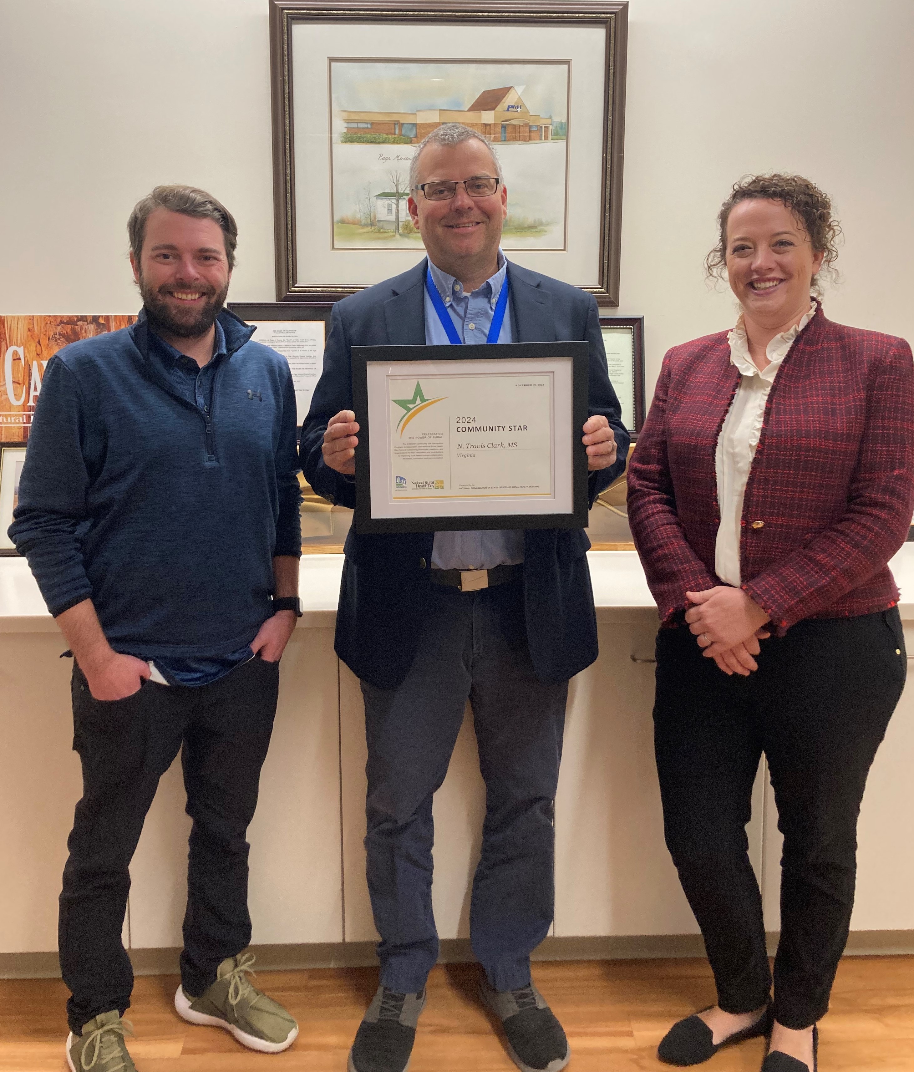 Brandon Rivenbark and Kandi Chamberlain with the Virginia Department of Health State Office or Rural Health present Travis Clark with the 2024 Community Star Award.